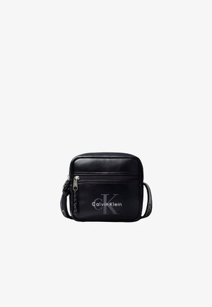 Czarna torba Calvin Klein na ramię z przednią kieszenią na suwak i logo CK, regulowany pasek z markowym detalem.