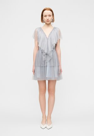 Világoskék tüll ruha lépcsőzetes fodrokkal, V-nyakkivágással és rövid ujjakkal. Áttetsző textúrával és csillogó részletekkel kiemelve.