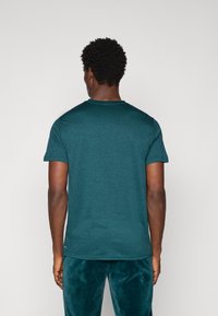Teal bomull T-skjorte med korte ermer og rund hals, designet med en jevn overflate og en avslappet passform.