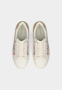 Ζευγάρι λευκά αθλητικά παπούτσια με κορδόνια, διακοσμημένα με λουλουδένιες πλαϊνές όψεις και το λογότυπο «ANNA FIELD» στις εσωτερικές σόλες και στις γλώσσες.