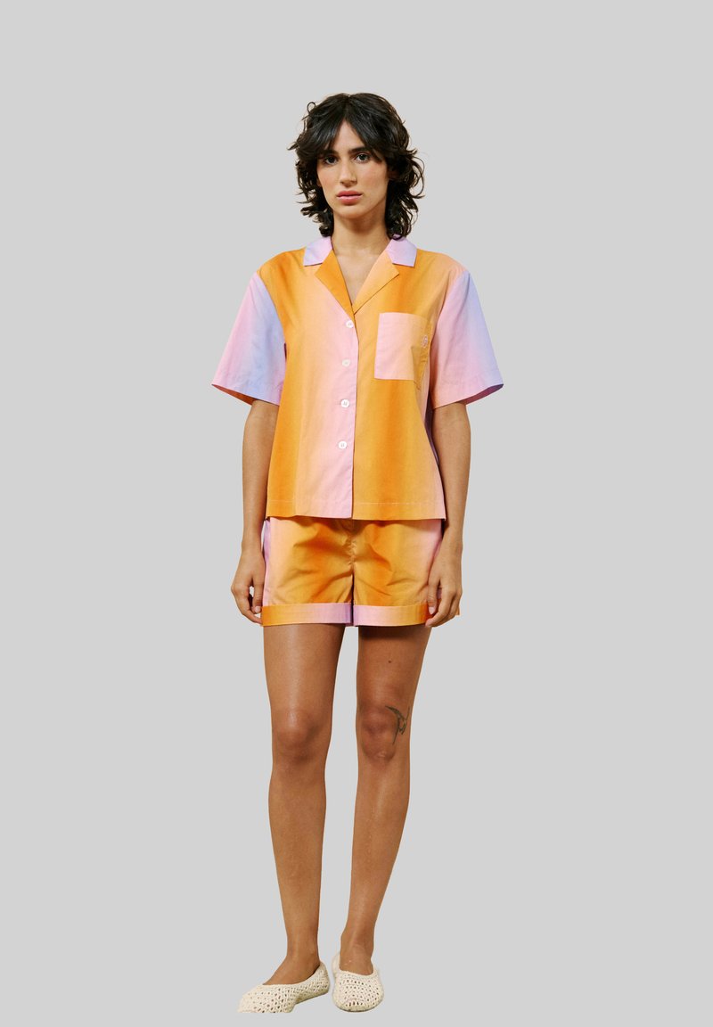 Korte mouwen pyjama set in een gradiënt van oranje en roze, met een knoopsluiting shirt met een zak en bijpassende shorts. Glad textuur van de stof.