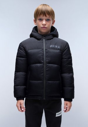 Chaqueta de plumas negra con capucha, con textura acolchada, cremallera frontal y detalle de logo en el pecho. Llevada con pantalones de chándal negros.