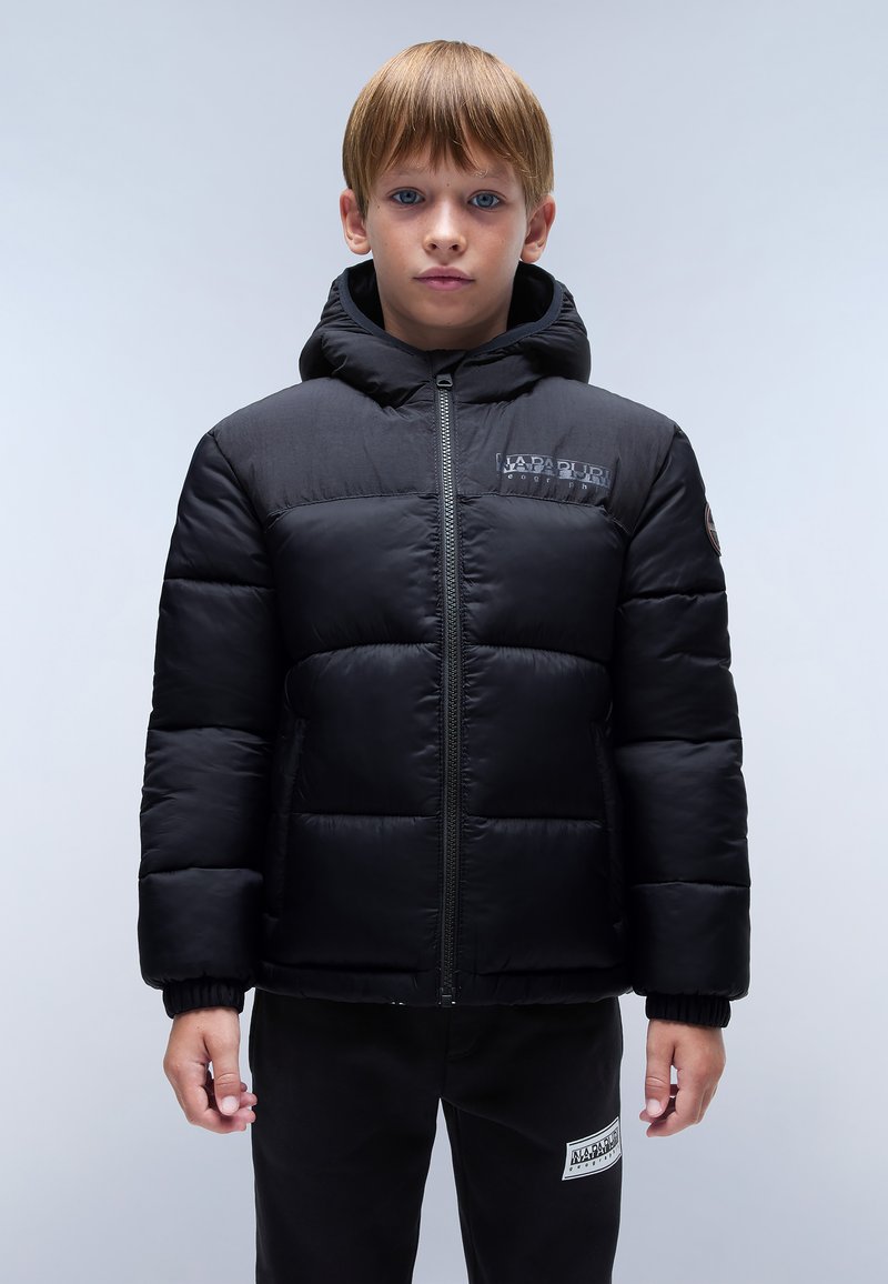 Czarna kurtka puchowa z kapturem, o pikowanej fakturze, z przednim zamkiem błyskawicznym i detalem z logo na klatce piersiowej. Noszona z czarnymi spodniami dresowymi.