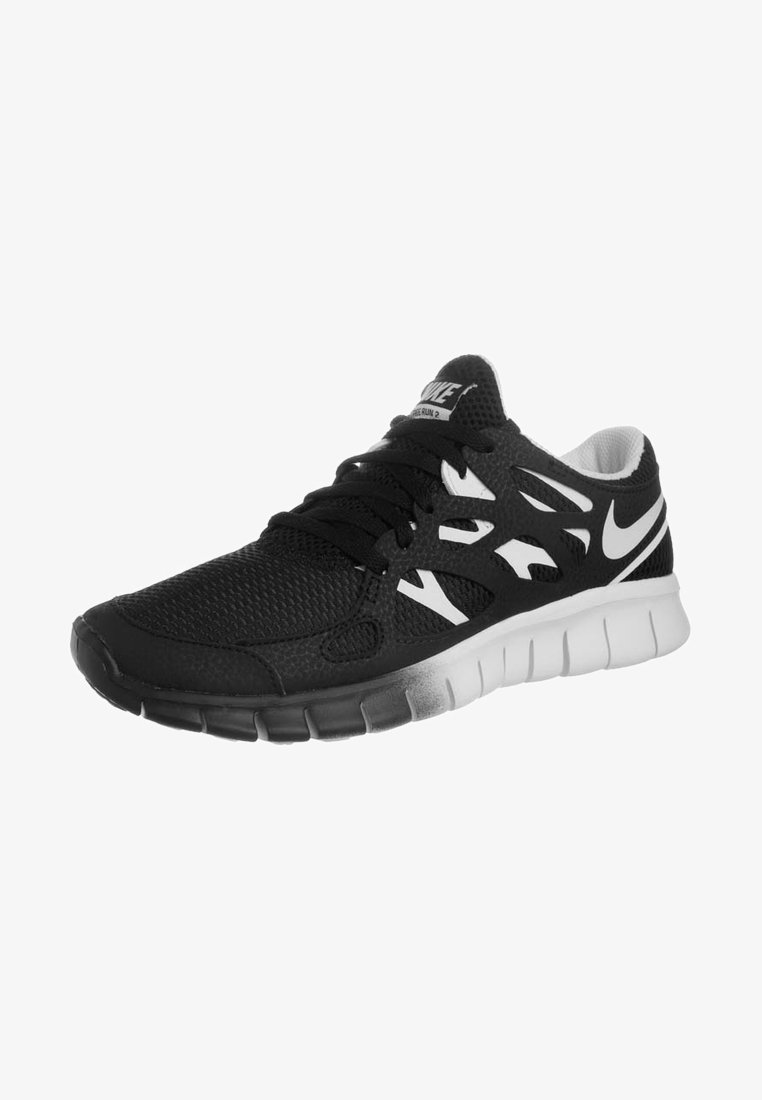 Chaussure de course Nike noire et blanche avec empeigne en mesh, fermeture à lacets et semelle flexible rainurée, inclinée pour montrer le côté extérieur.