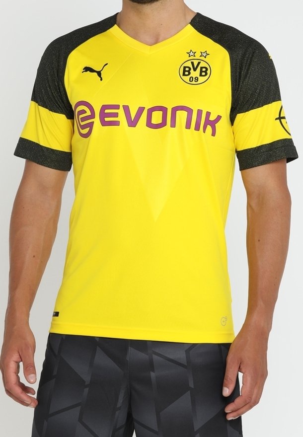 Gul sportströja med svarta texturerade ärmar, med Puma-logotypen, "Evonik" i lila och en klubbemblem med två stjärnor.