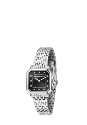 Sølvmetalt armbåndsur med sort ottekantet urskive, krystalltimemarkører og "KARL LAGERFELD" branding på urskiven.