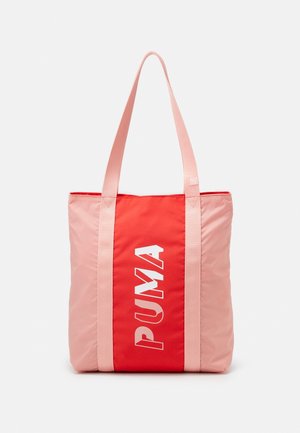 Sac fourre-tout avec anses et côtés roses, panneau central rouge présentant le logo « "PUMA" » en lettres blanches verticales.