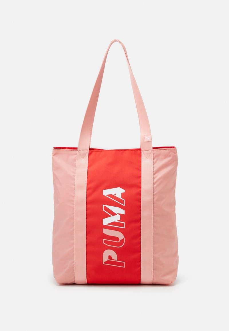 Sac fourre-tout avec anses et côtés roses, panneau central rouge présentant le logo « "PUMA" » en lettres blanches verticales.