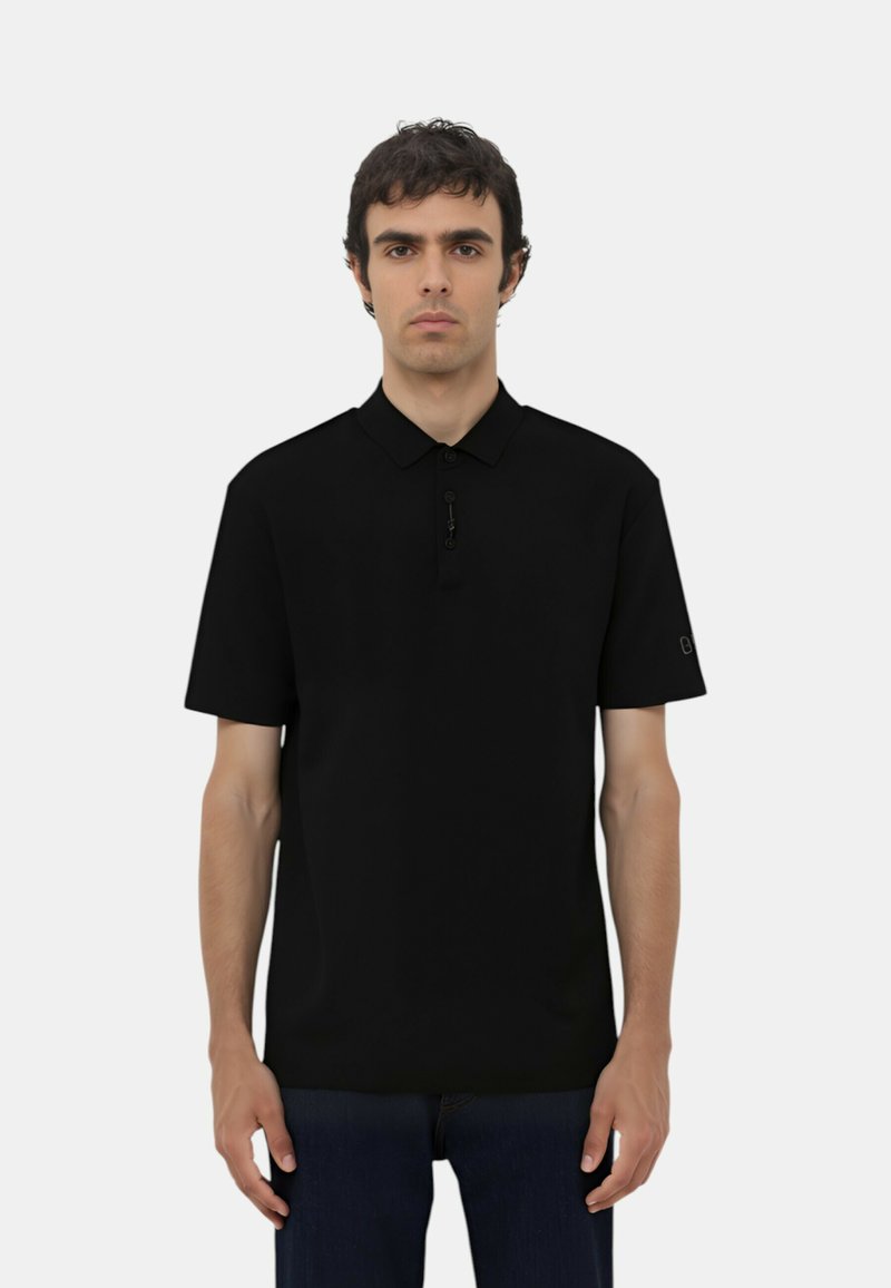 Polo shirt nero a maniche corte con colletto, dotato di un dettaglio con zip sul collo e un logo sulla manica destra. Tessuto morbido.