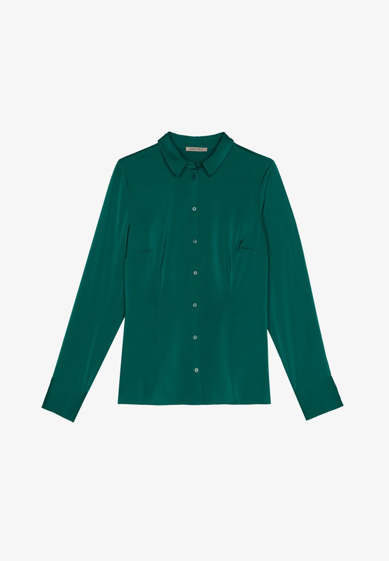 Türaubergine Langarmbluse aus glattem Stoff mit einem spitzen Kragen, durchgehender Knopfleiste und zwei Brusttaschen.