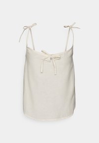 Camisola de linho em bege claro com alças ajustáveis, um detalhe de laço central e uma bainha arredondada. Textura suave e design casual.