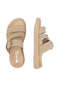 Sandales décontractées beiges avec un design à trois lanières, dont une avec une boucle circulaire. Matériau doux semblable au daim avec une semelle intérieure texturée et une semelle légère.