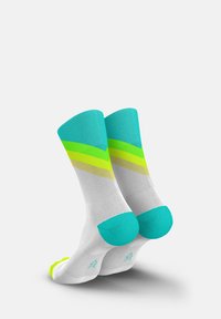 Colorful socks featuring a white body, turquoise accents, and green/yellow striped patterns. Made from a soft, stretchy fabric for comfort.