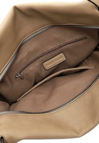 Light brown leather handbag interior featuring a zippered pocket and smooth fabric lining. Notable stitching detail along the edges.