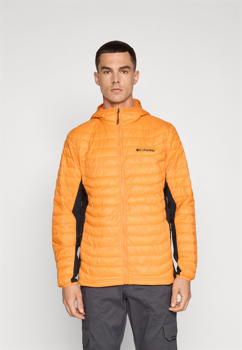 Veste isolante orange avec un motif matelassé, panneaux latéraux noirs contrastants et capuche. Comprend une fermeture éclair à l'avant et un logo sur la poitrine gauche.