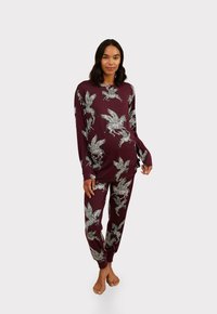 Maroon pajama set with long-sleeve top and elastic waistband pants featuring white leaf and zebra patterns; soft fabric with relaxed fit.