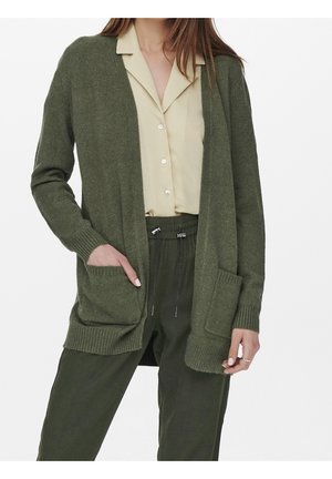 Olivgrüner Strickcardigan mit offener Vorderseite, gerippten Bündchen und zwei Vorder pockets, über einem beigefarbenen Hemd mit Kragen getragen.
