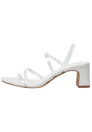 Sandalia blanca de tacón con tiras de plástico transparente, tacón ancho y suela lisa. El diseño presenta punta abierta y detalles mínimos.