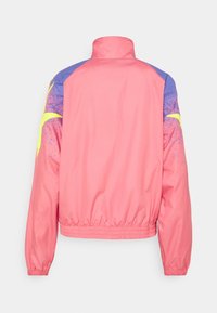 Pink jacket with a high collar, elastic hem, and gathered cuffs, featuring blue and yellow accents on the shoulders and a textured finish.
