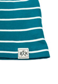 Teal-värinen raidoitettu kangas, jossa on valkoisia vaaleita vaakaraitoja. Sisältää etiketin, jossa on "BR" ja risteävät symbolit. Pehmeä puuvillatekstuuri, huolellisesti ommellut reunat.