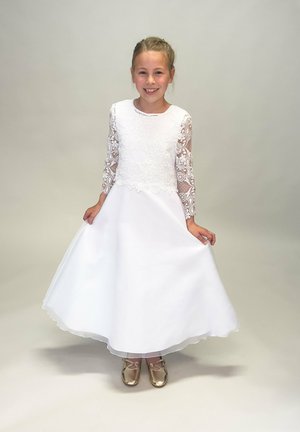 Weißes Kleid mit bestickten Spitzenärmeln, geraffter Taille und fließendem Rock. Kombiniert mit goldenen Schuhen. Glatter Stoff, knielanges Design.