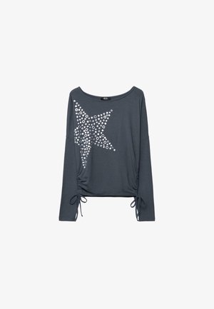 Dunkelgraues Langarmoberteil mit einem großen silbernen Stern aus runden Nieten auf der Vorderseite und Kordelzügen am Saum.