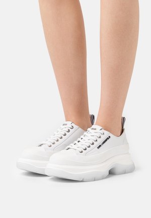 Baskets à plateforme blanches avec une tige en cuir lisse. Dotées d'œillets métalliques, d'une semelle épaisse et d'un détail de logo sur le côté et la languette du talon.