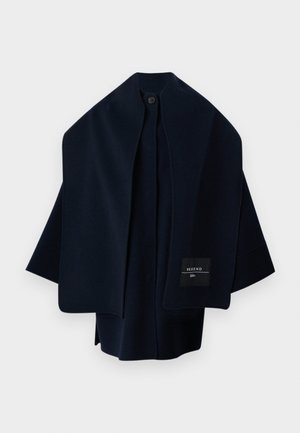Cape manteau en laine bleu marine foncé avec col large, fermeture à un bouton et étiquette "Weekend" sur le côté avant droit.