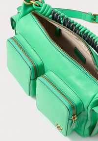 Borsa a tracolla in pelle verde con due tasche frontali con zip, dettagli in zip dorati e una maniglia intrecciata in pelle verde e nera.
