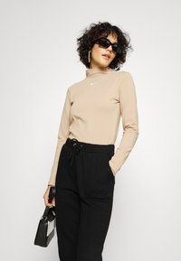 NA-KD PAMELA REIF x NA-KD - TRACKSUIT BOTTOMS - Calças de fato de treino - black