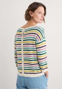 Sweter w paski w kolorach zielonym, żółtym, fioletowym i niebieskim. Dzianina z okrągłym dekoltem i detalem z guzikami z tyłu. Luźny krój.