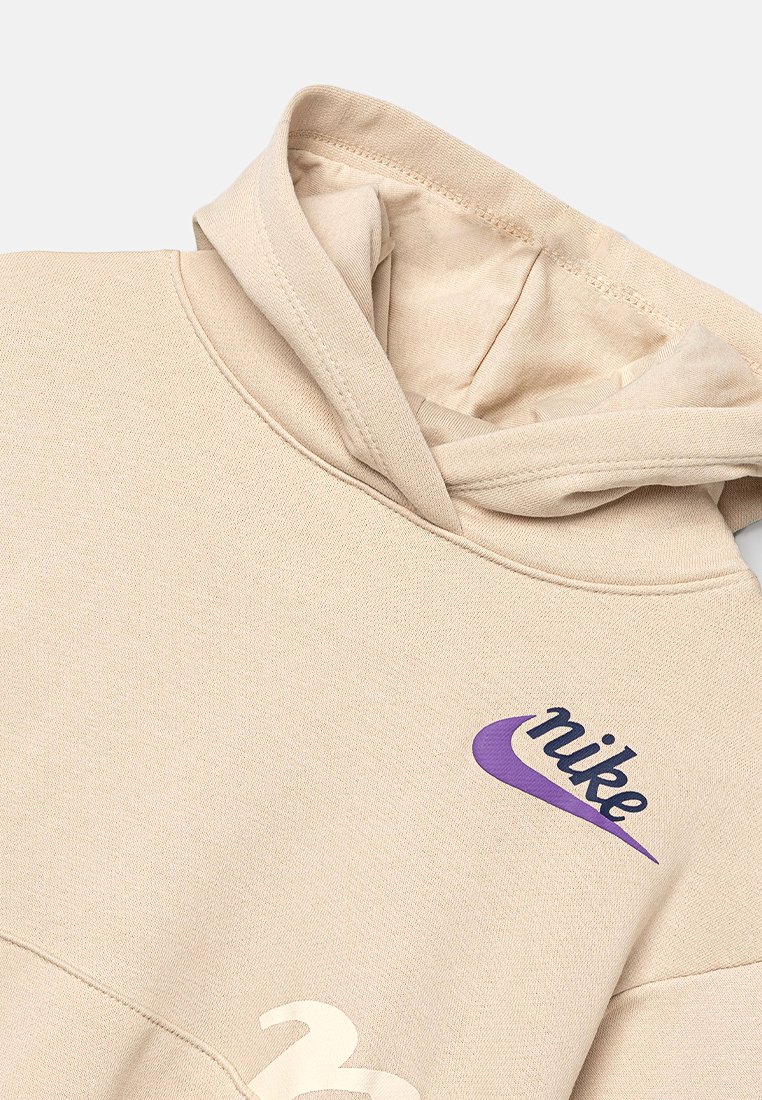 Sweatshirt à capuche beige en mélange de coton, avec un logo Nike violet et un détail graphique blanc à l'avant. Texture douce, design décontracté.