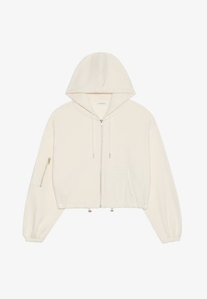 Krótkie białe hoodie wykonane z miękkiego materiału, z przodu zapinane na zamek błyskawiczny, z regulowanym sznurkiem oraz kieszenią zapinaną na zamek na rękawie. Długie, obszerne rękawy.