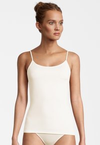 Cream-colored camisole with thin straps, made from smooth, stretchy fabric. Fitted design with a rounded neckline and seamless sides.