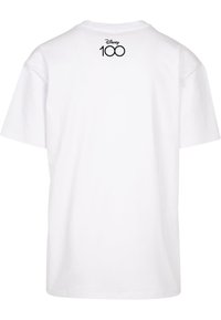 Hvit bomull T-skjorte med korte ermer, med en enkel rund halsutringning. "Disney 100"-logoen trykket i svart nær den øvre ryggen.