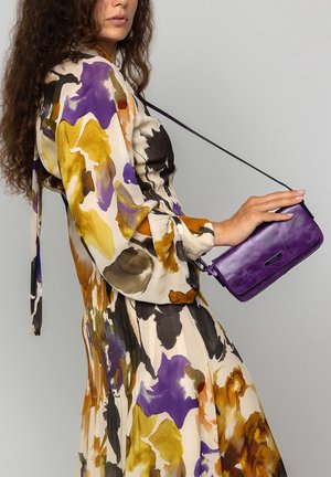 Floral patterned dress in cream, purple, yellow, and black with long sleeves and a tie. Violet leather clutch with a shoulder strap.