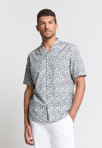 Korte mouw knopsluiting overhemd met een geometrisch patroon in blauw, beige en grijs op een lichte achtergrond, gemaakt van geweven stof.