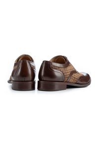 Chaussures en cuir marron avec des panneaux texturés au motif pied-de-poule, bout arrondi et un talon modéré pour la stabilité.