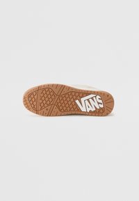 Smeđa guma donji dio s teksturiranim uzorkom, s bijelim "VANS" logotipom istaknutim sa strane.