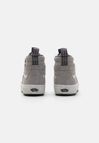 Zapatillas altas grises de ante y textil, con suela de goma blanca y lengüeta trasera texturizada. Presenta el logo en el talón.