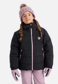 Jeune fille avec des tresses portant une doudoune noire, un bonnet tricoté rose avec un pompon, des gants roses et un pantalon rose, faisant face à l'avant.