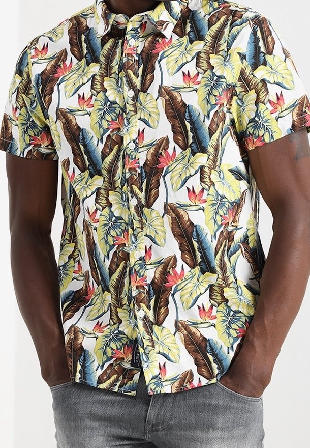Camicia a maniche corte con bottoni, caratterizzata da un vivace motivo a foglie tropicali in verde, marrone e rosso su sfondo bianco. Tessuto in cotone, vestibilità rilassata.