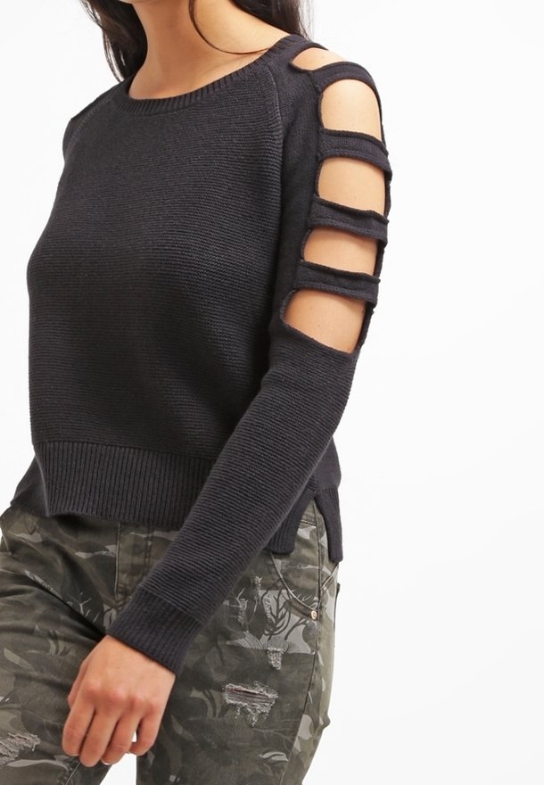 Czarny sweter z dzianiny z otwartymi rękawami, poziomymi wycięciami, prążkowanym dołem oraz długimi, dopasowanymi rękawami. W zestawieniu z spodniami w kamuflażowy wzór.