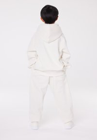 Champion EXCLUSIVE HOODIE UNISEX - Sportinis megztinis - off-white