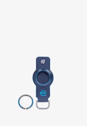 Llavero de cuero en azul marino diseñado para Apple AirTag, con cierre circular y anilla metálica junto a él.