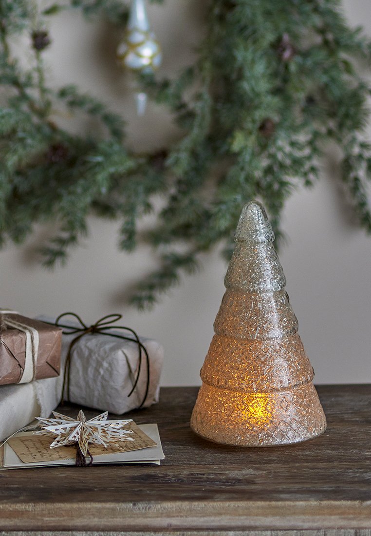 Glazen kerstboomdecoratie, afgewerkt met een textuur in verloopkleuren van helder en gefrost, met een warme gloed aan de basis.