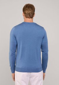 Pull bleu clair en texture tricotée avec un col rond et des manches longues ; présente des poignets et un ourlet côtelés.