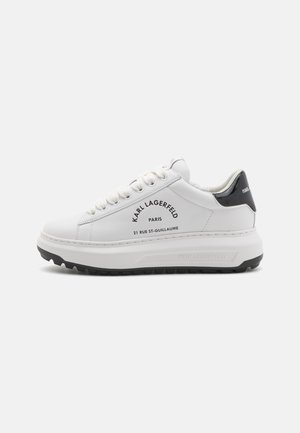 Baskets basses blanches à semelle épaisse, languette de talon noire, lacets blancs, avec le logo noir "Karl Lagerfeld Paris 21 Rue St-Guillaume" sur le côté.