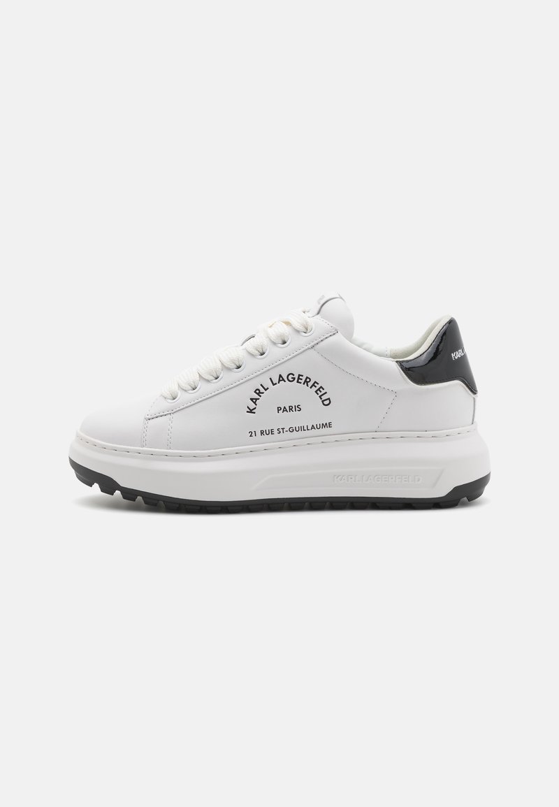 Baskets basses blanches à semelle épaisse, languette de talon noire, lacets blancs, avec le logo noir "Karl Lagerfeld Paris 21 Rue St-Guillaume" sur le côté.