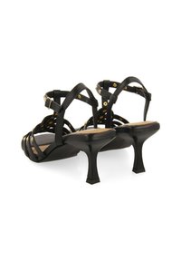 Sandalias de tacón negro con correas entrelazadas, detalles dorados y un acabado brillante. Presenta un tacón curvado y una suela texturizada para mayor agarre.